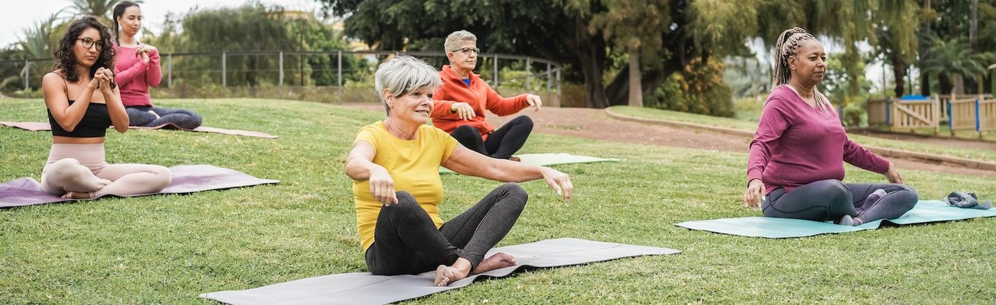 employees doing yoga in the park