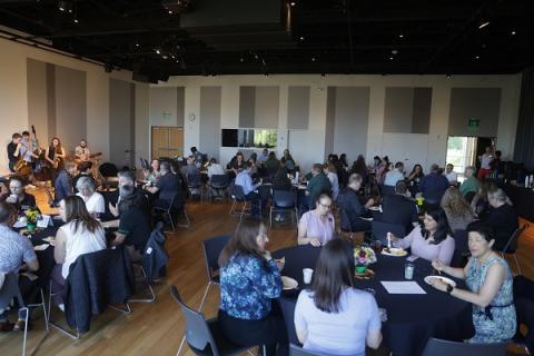 employees sitting at tables and enjoying the years of service brunch