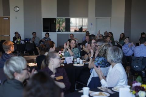 employees at the brunch, person in center of image is clapping