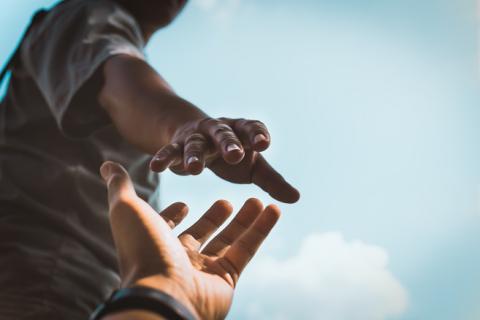 person extending a hand to help another