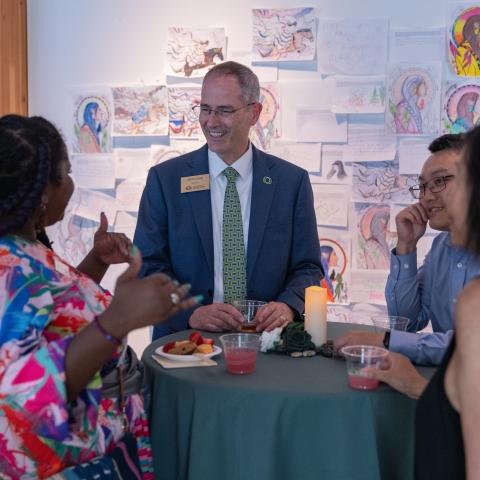 provost talking to employees at a table