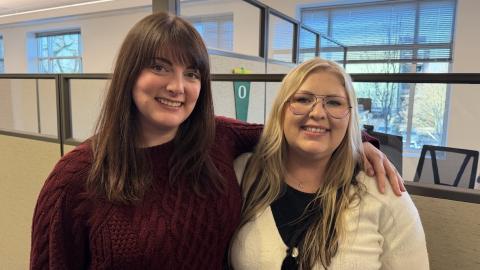 office setting with two relaxed and smiling employees
